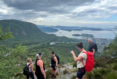 Turgruppe på fjelltopp med utsikt over fjorden ved Jørpeland