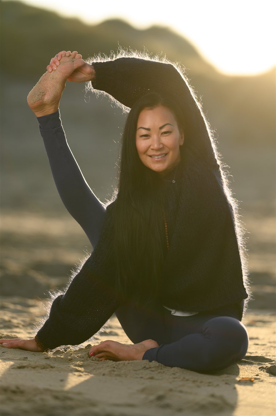 Rolig yogastilling på stranden i gyllent kveldslys
